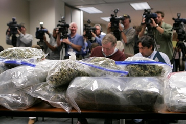 Image of TV cameras aimed at bags of pot